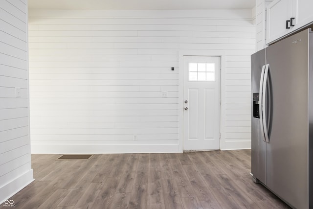 1456 Fletcher Ave, Indianapolis, IN 46203 - kitchen with stainless steel refrigerator with ice dispenser, white cabinets, dark wood finished floors, and wood walls