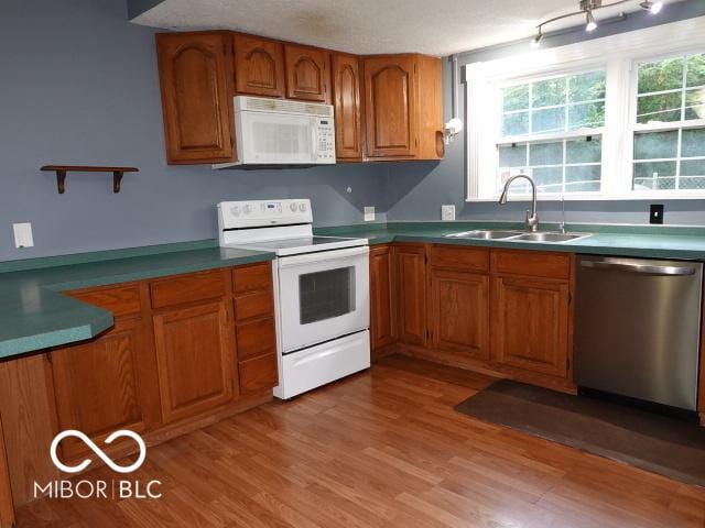kitchen with white appliances, brown cabinets, light wood-type flooring, and open shelves