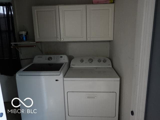 laundry area with washing machine and dryer and cabinet space