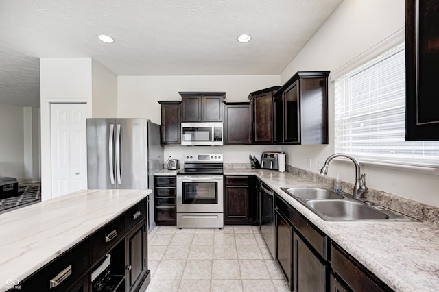 1270 W Limestone Way, Fortville, IN 46040 - kitchen featuring stainless steel appliances, a textured ceiling, recessed lighting, dark brown cabinets, and light stone counters