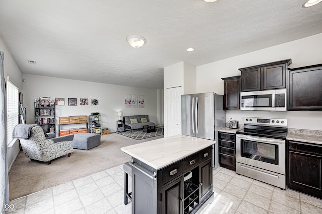 1270 W Limestone Way, Fortville, IN 46040 - kitchen with appliances with stainless steel finishes, open floor plan, a kitchen island, recessed lighting, and light flooring