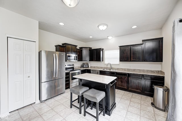 1270 W Limestone Way, Fortville, IN 46040 - kitchen with stainless steel appliances, a breakfast bar area, dark brown cabinetry, a center island, and recessed lighting