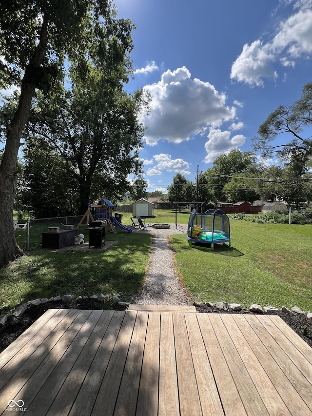 1203 S 6th St, Clinton, IN 47842 - deck with a playground, a storage shed, a trampoline, and a fenced backyard