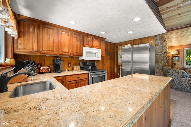 6254 Grosbeak Ct, Nineveh, IN 46164 - kitchen featuring stainless steel appliances, light stone countertops, wood walls, brown cabinetry, and carpet flooring