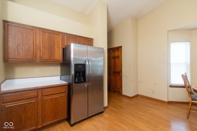 4625 Pine Park Ln, Indianapolis, IN 46268 - kitchen featuring stainless steel refrigerator with ice dispenser, brown cabinetry, light wood finished floors, and light countertops