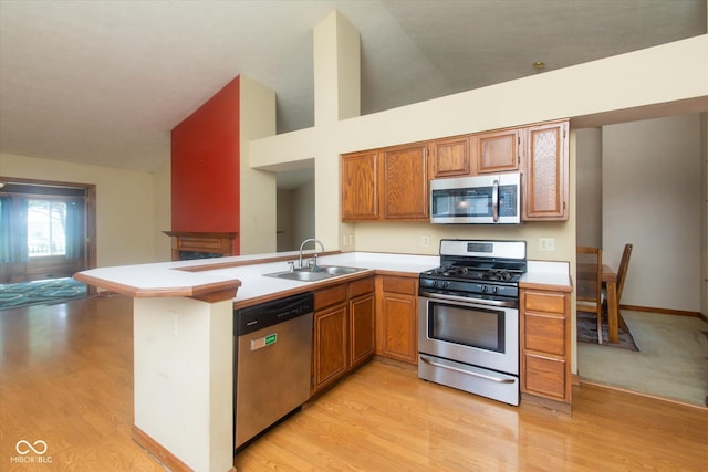 4625 Pine Park Ln, Indianapolis, IN 46268 - kitchen featuring stainless steel appliances, vaulted ceiling, light wood-type flooring, light countertops, and a peninsula