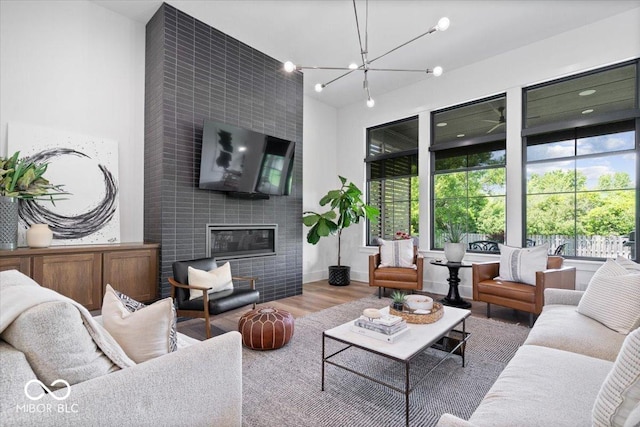 20440 Chatham Hills Blvd, Westfield, IN 46074 - living room with a fireplace, healthy amount of natural light, a chandelier, wood finished floors, and a towering ceiling
