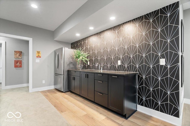 20440 Chatham Hills Blvd, Westfield, IN 46074 - kitchen featuring an accent wall, freestanding refrigerator, recessed lighting, light wood-type flooring, and dark countertops