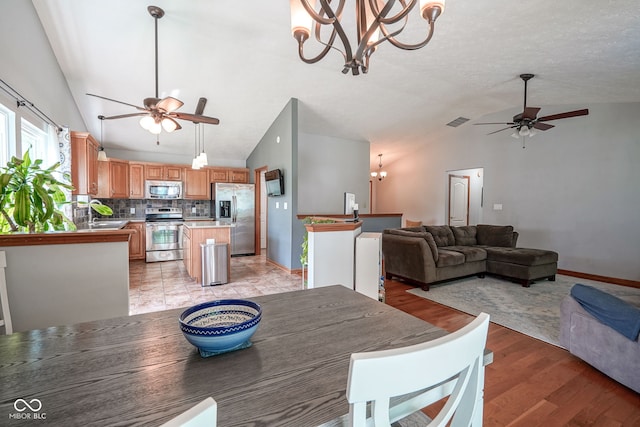 1804 Emerald Pines Ln, Westfield, IN 46074 - dining space with a ceiling fan, vaulted ceiling, a chandelier, and light wood-style floors
