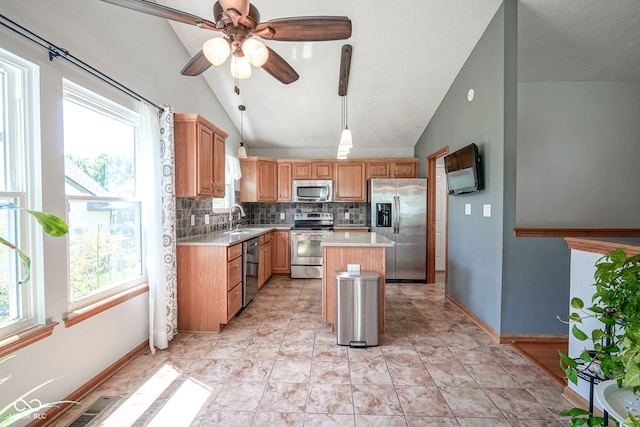1804 Emerald Pines Ln, Westfield, IN 46074 - kitchen with appliances with stainless steel finishes, lofted ceiling, tasteful backsplash, light countertops, and a kitchen island