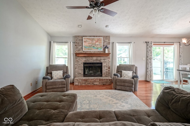 1804 Emerald Pines Ln, Westfield, IN 46074 - living area with a textured ceiling, wood finished floors, ceiling fan, a fireplace, and a chandelier