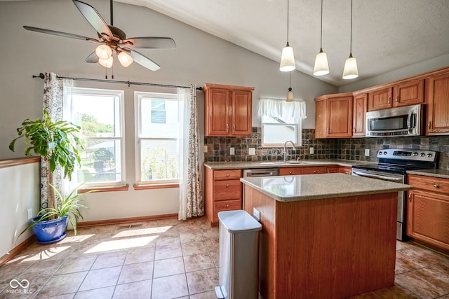 1804 Emerald Pines Ln, Westfield, IN 46074 - kitchen featuring stainless steel appliances, vaulted ceiling, tasteful backsplash, a center island, and ceiling fan