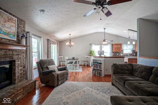 1804 Emerald Pines Ln, Westfield, IN 46074 - living room featuring ceiling fan, vaulted ceiling, a chandelier, light wood-type flooring, and a textured ceiling