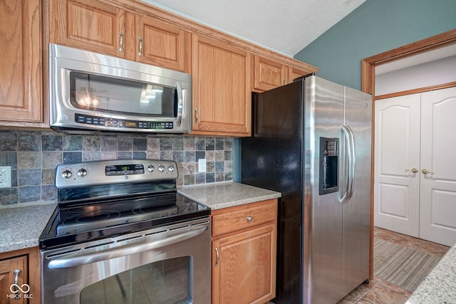 1804 Emerald Pines Ln, Westfield, IN 46074 - kitchen featuring stainless steel appliances, tasteful backsplash, light stone countertops, and brown cabinets