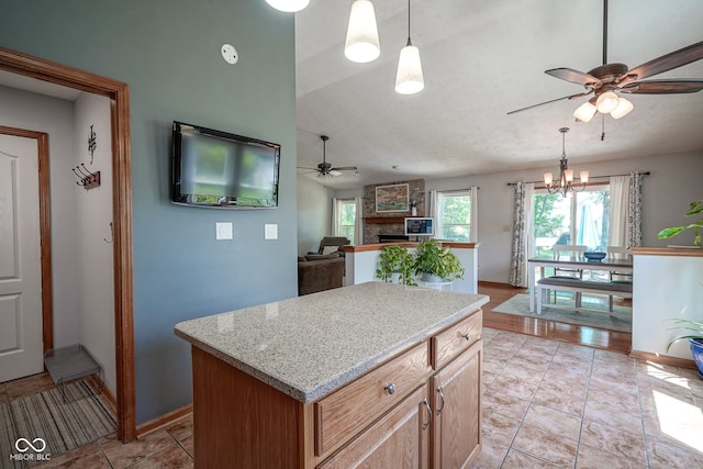 1804 Emerald Pines Ln, Westfield, IN 46074 - kitchen featuring ceiling fan, a fireplace, a chandelier, decorative light fixtures, and vaulted ceiling
