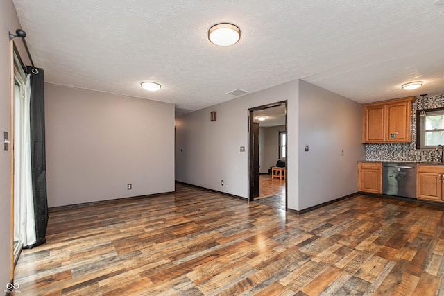 1202 E Stop 10th Rd, Indianapolis, IN 46227 - kitchen featuring dishwasher, dark wood finished floors, decorative backsplash, a textured ceiling, and brown cabinetry