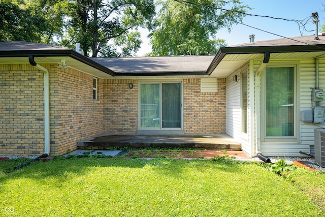 1202 E Stop 10th Rd, Indianapolis, IN 46227 - doorway to property featuring a lawn, brick siding, a patio area, and a shingled roof