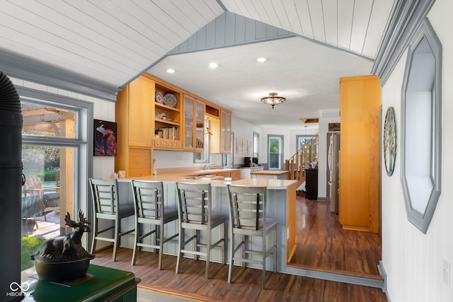 13421 Bellsville Pike, Columbus, IN 47201 - kitchen with a peninsula, dark wood-style floors, light countertops, lofted ceiling, and a kitchen breakfast bar
