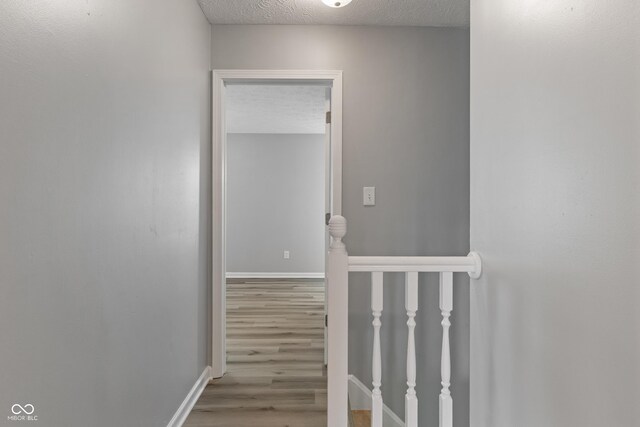 2359 Bremhaven Ct, Indianapolis, IN 46229 - corridor with an upstairs landing, wood finished floors, and a textured ceiling