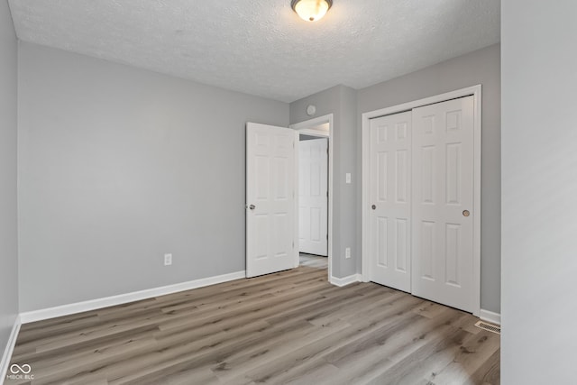 2359 Bremhaven Ct, Indianapolis, IN 46229 - unfurnished bedroom featuring wood finished floors, a textured ceiling, and a closet