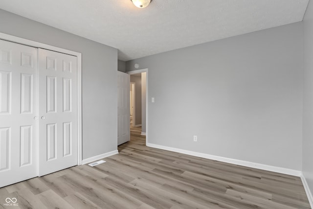2359 Bremhaven Ct, Indianapolis, IN 46229 - unfurnished bedroom with light wood finished floors, a closet, and a textured ceiling