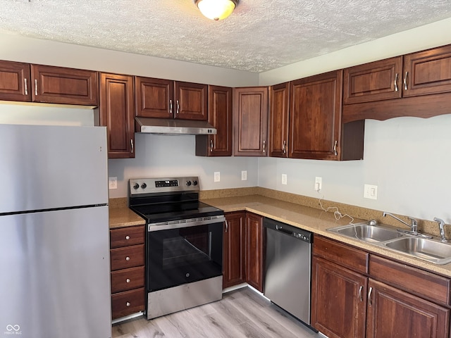 2359 Bremhaven Ct, Indianapolis, IN 46229 - kitchen featuring stainless steel appliances, under cabinet range hood, light wood-style flooring, light countertops, and a textured ceiling