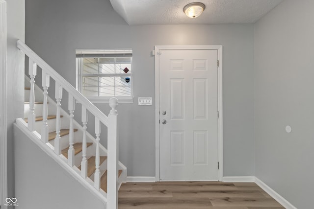 2359 Bremhaven Ct, Indianapolis, IN 46229 - entryway with wood finished floors, stairs, and a textured ceiling