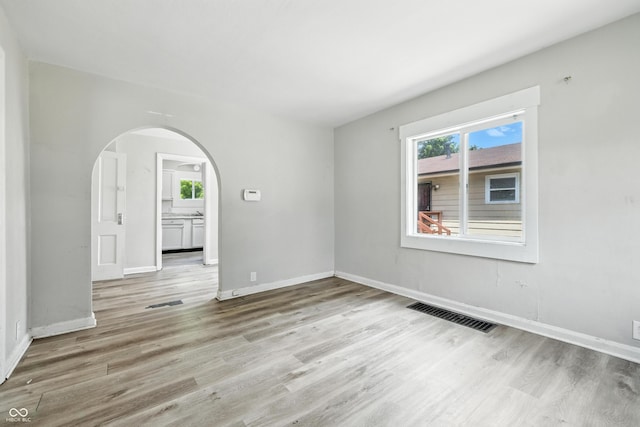 3424 Orchard Ave, Indianapolis, IN 46218 - empty room featuring arched walkways and light wood-style flooring