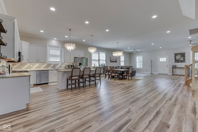 847 E Jefferson St, Franklin, IN 46131 - kitchen featuring appliances with stainless steel finishes, a chandelier, open floor plan, a kitchen island, and a kitchen bar