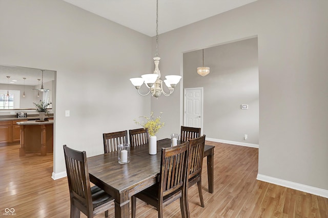 421 Lowry St, Jamestown, IN 46147 - dining space featuring light wood-style flooring, a chandelier, and a towering ceiling