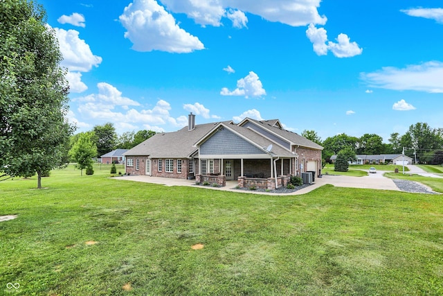 421 Lowry St, Jamestown, IN 46147 - back of house featuring concrete driveway, brick siding, an attached garage, a lawn, and a patio