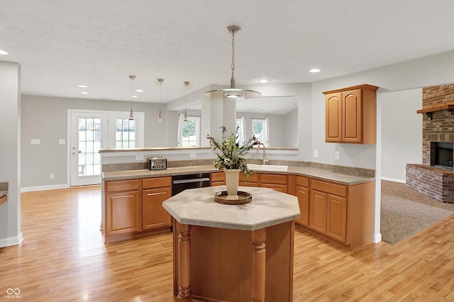 421 Lowry St, Jamestown, IN 46147 - kitchen featuring light wood finished floors, light countertops, a fireplace, a peninsula, and plenty of natural light