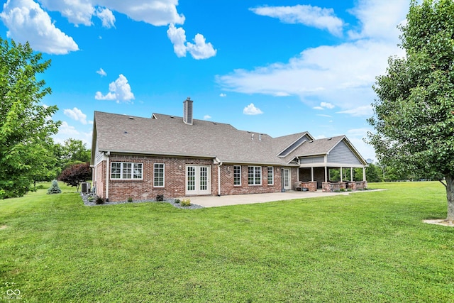 421 Lowry St, Jamestown, IN 46147 - back of house with brick siding, a patio area, a chimney, a lawn, and roof with shingles