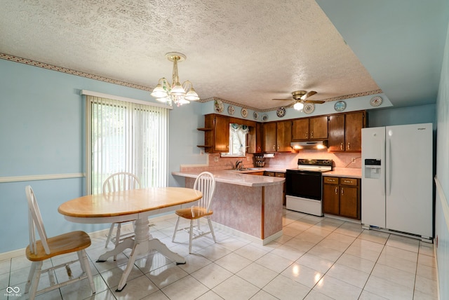 5425 Gambel Rd, Indianapolis, IN 46221 - kitchen featuring white appliances, under cabinet range hood, a peninsula, light countertops, and a textured ceiling