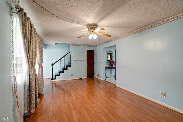 5425 Gambel Rd, Indianapolis, IN 46221 - unfurnished room featuring stairway, ceiling fan, wood finished floors, and a textured ceiling
