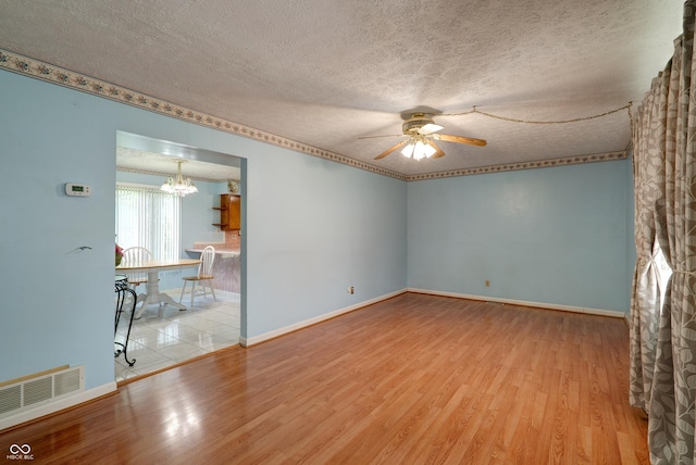 5425 Gambel Rd, Indianapolis, IN 46221 - unfurnished room with wood finished floors, a ceiling fan, a textured ceiling, and a chandelier