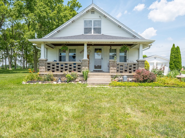 1556 E 400 S, Greenfield, IN 46140 - view of front facade featuring a front lawn, covered porch, roof with shingles, and stone siding