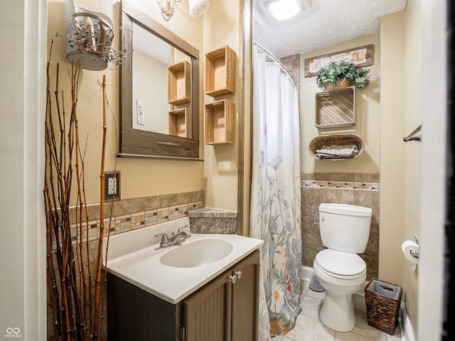 1556 E 400 S, Greenfield, IN 46140 - full bath with tile walls, tile patterned floors, vanity, a textured ceiling, and a wainscoted wall