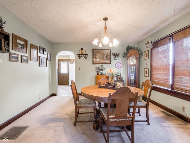 1556 E 400 S, Greenfield, IN 46140 - dining space featuring arched walkways, light carpet, a textured ceiling, and a chandelier