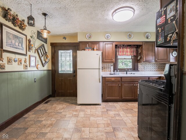 1556 E 400 S, Greenfield, IN 46140 - kitchen with freestanding refrigerator, gas stove, light countertops, backsplash, and a wainscoted wall