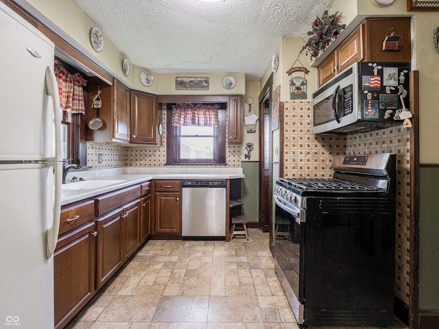 1556 E 400 S, Greenfield, IN 46140 - kitchen with stainless steel appliances, tasteful backsplash, light countertops, a textured ceiling, and light stone finish floors