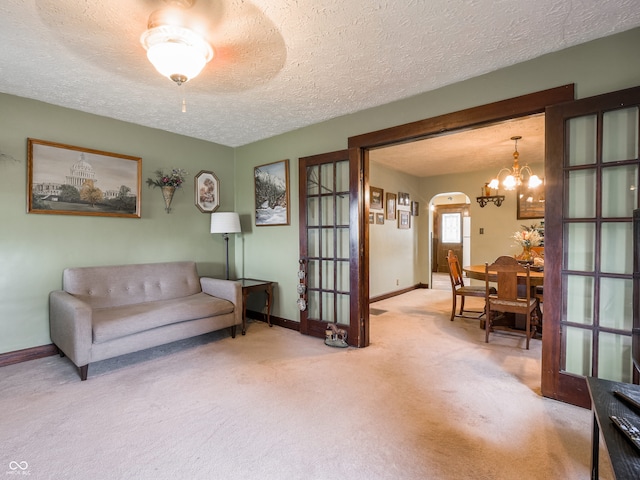 1556 E 400 S, Greenfield, IN 46140 - living area featuring carpet floors, arched walkways, a textured ceiling, french doors, and a chandelier