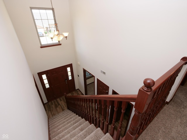 4443 W Windsong Ct, New Palestine, IN 46163 - stairway with a chandelier, a high ceiling, and carpet