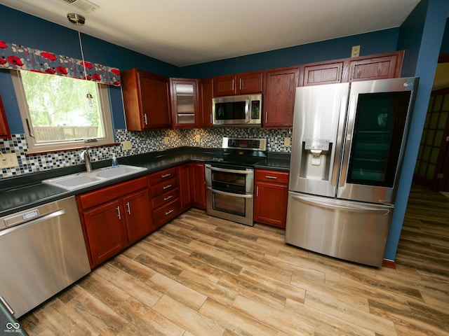 4443 W Windsong Ct, New Palestine, IN 46163 - kitchen featuring appliances with stainless steel finishes, dark countertops, and light wood-style floors