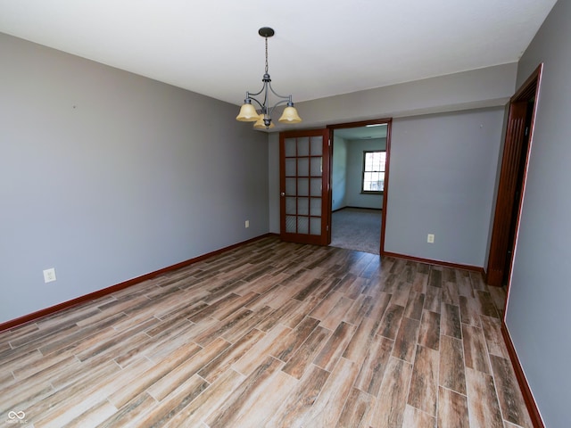 4443 W Windsong Ct, New Palestine, IN 46163 - empty room with wood finished floors and a chandelier