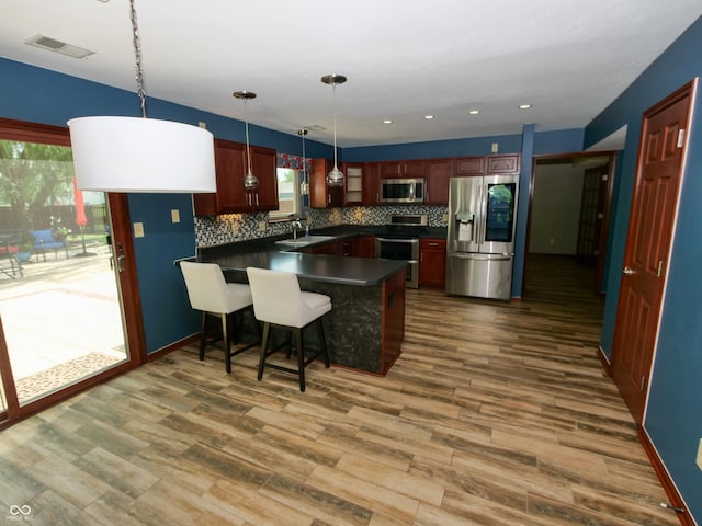 4443 W Windsong Ct, New Palestine, IN 46163 - kitchen featuring stainless steel appliances, dark countertops, healthy amount of natural light, decorative backsplash, and recessed lighting