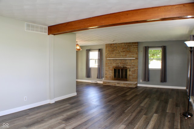 9808 E Troy Ave, Indianapolis, IN 46239 - unfurnished living room featuring a stone fireplace, wood finished floors, and beam ceiling