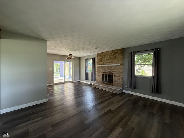 9808 E Troy Ave, Indianapolis, IN 46239 - unfurnished living room with plenty of natural light, dark wood finished floors, and a stone fireplace