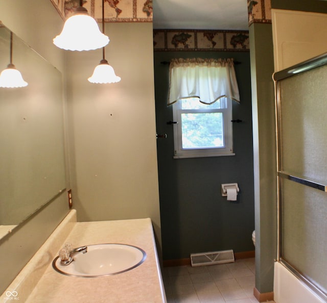 9808 E Troy Ave, Indianapolis, IN 46239 - full bathroom featuring vanity, tile patterned flooring, and combined bath / shower with glass door
