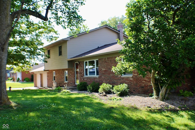 9808 E Troy Ave, Indianapolis, IN 46239 - view of front of house with brick siding, a chimney, a front yard, and an attached garage